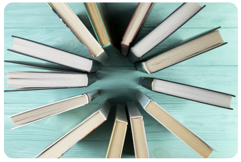 Das Bild zeigt Bücher von oben die in einem Kreis angeordnet sind