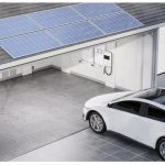 Ein E-Auto fährt in eine Garage mit Solarpanelen