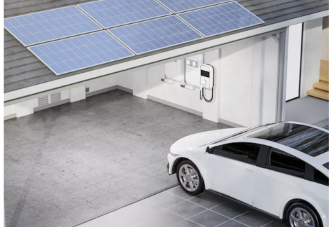 Ein E-Auto fährt in eine Garage mit Solarpanelen